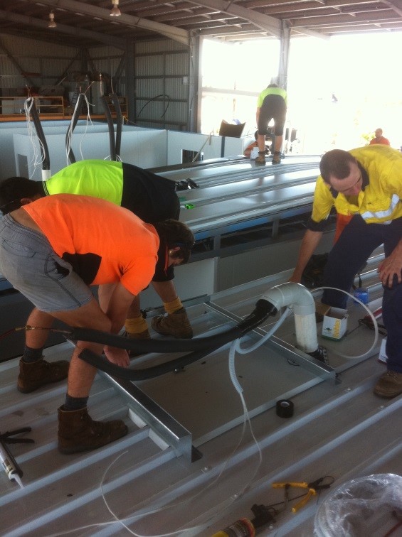 Johnny Cool Darwin team fitting off the Electrical wiring and cabling for roof mounted condensors